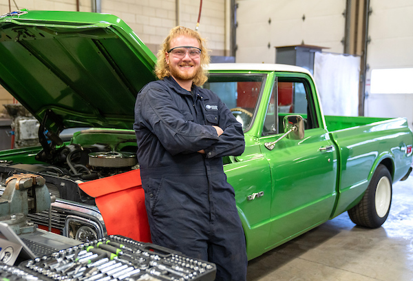 COCC automotive student beside a vehicle
