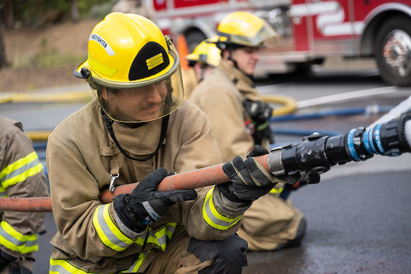 COCC fire science student training with a fire hose
