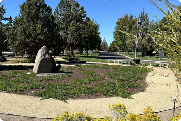Outside area on the Redmond COCC Campus that features bench seating and stone statue