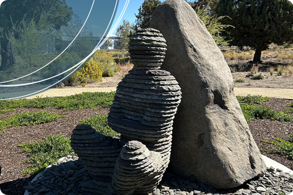 Stone statue of a person meditating against a rock