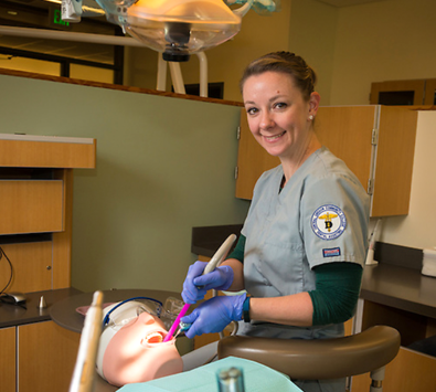 Student practicing dental hygiene on a mannequin