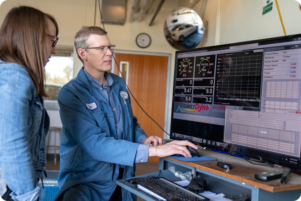Automotive professor showing a student vehicle benchmarks on a computer screen
