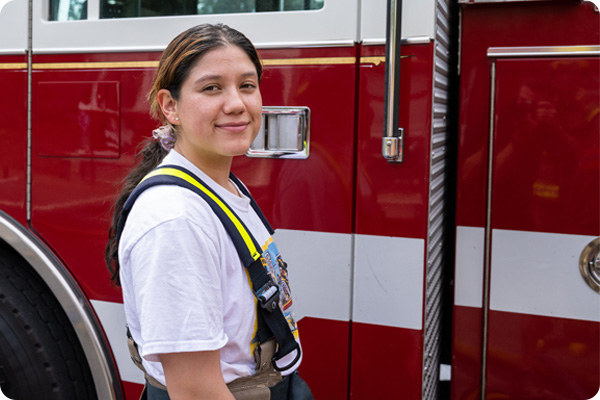 Fire Science student smiling in front of a fire truck