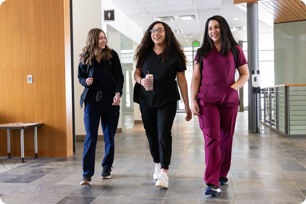 Students in scrubs walking together down a hallway