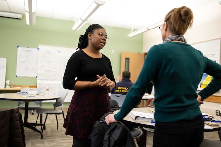 student and instructor having a discussion in a classroom