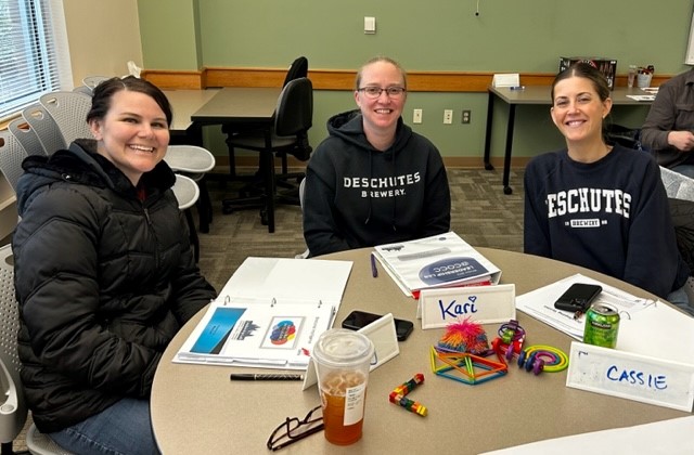 3 coworkers at a table taking a professional training class