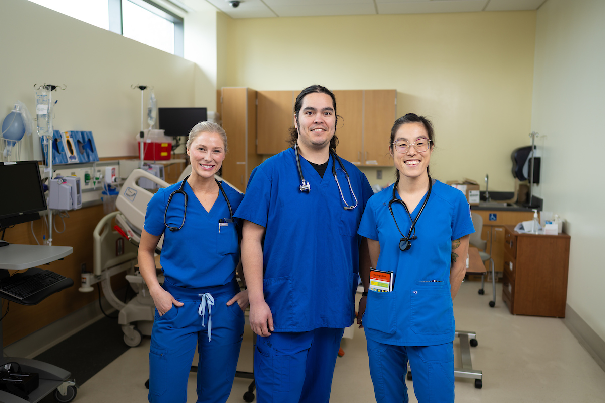 3 smiling health care professionals posing in a clinical room