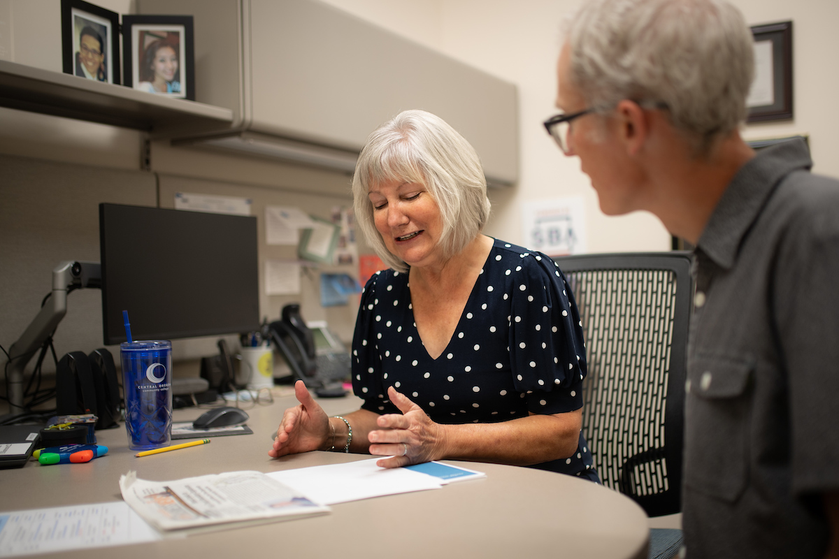 business persons discussing something at a desk