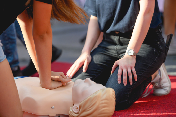 Students practice giving CPR to a CPR dummy