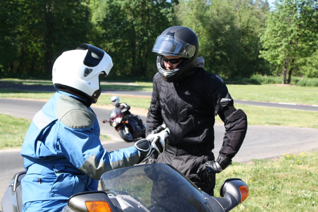 Instructor and student discussing road safety while on a motorcycle
