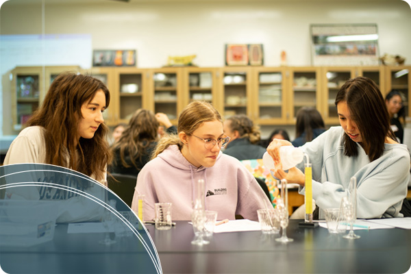 high schoolers measuring liquid into a test tube