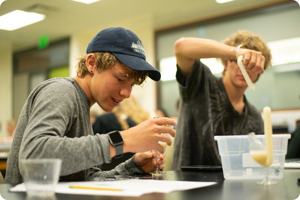 two high school students performing a science experiment