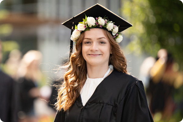 smiling COCC Grad at Commencement wearing a flower crown
