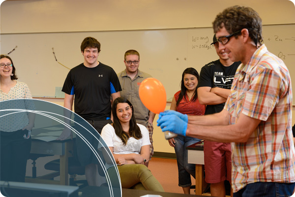 Physics professor instructing students through a physics lab using ballons