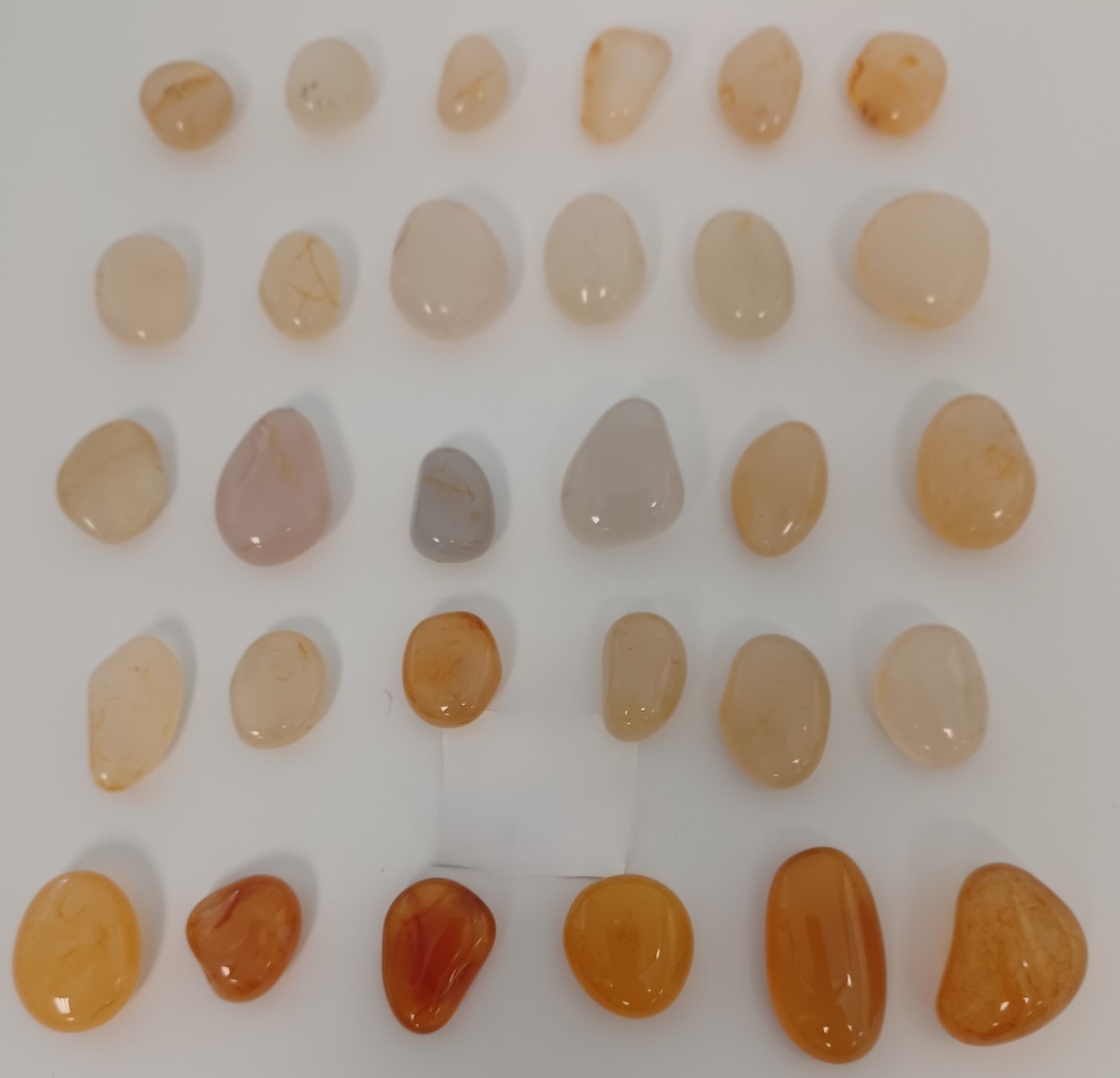 Smooth round polished Alaska Moonstone, ranging in colors from white to gray to amber. 