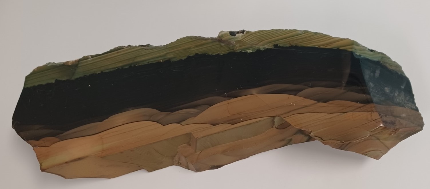 A single example showing clear layers of green, black and brown rock. 