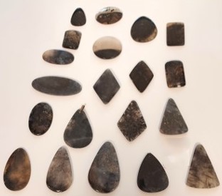 Polished agates in mostly dark colors, including nearly solid black. 