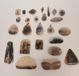 Polished white agates with dark inclusions that resemble ferns or corals.