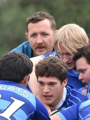 Rugby Coach, Max Bennett participating in a team huddle