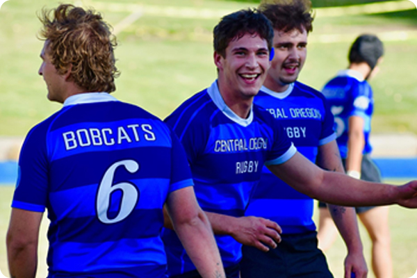 2 rugby players smiling towards the camera