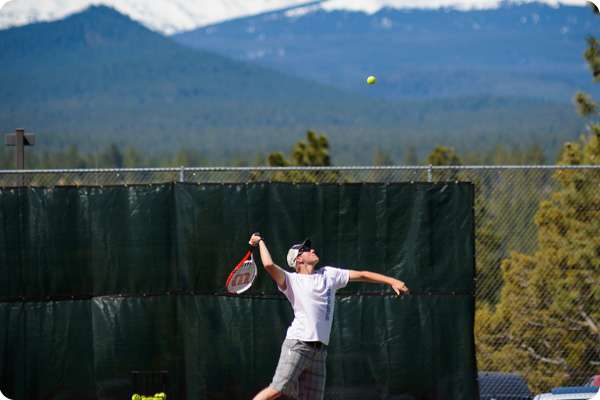 tennis player in the middle of serving the tennis ball