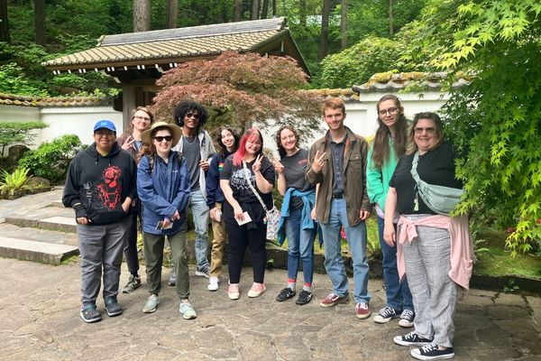 Group of students in the Asian Cultures Club smiling for a picture at the Japanese Garden. 