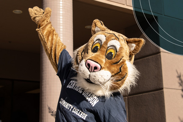 COCC Bobcat waving in front of Boyle Education Center
