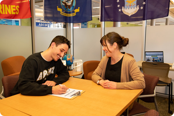 Bonnie Jordan helping a veteran student fill out scholarship forms