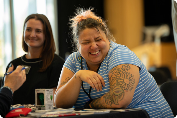 Students laughing with a Veterans Affair Coordinator at the Veterans Resource Fair