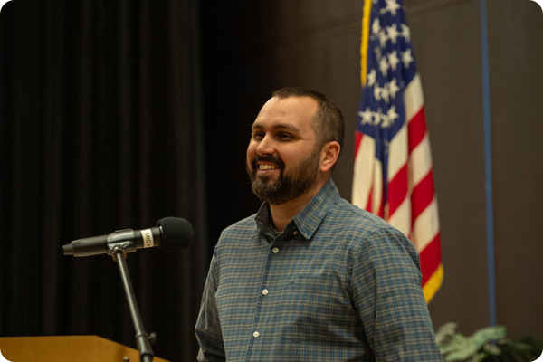 Student Veteran speaking at a podium in front of an audience