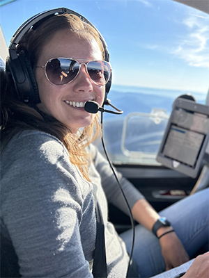 Kamilla Farkas smiling in the cockpit of a fixed wing aircraft