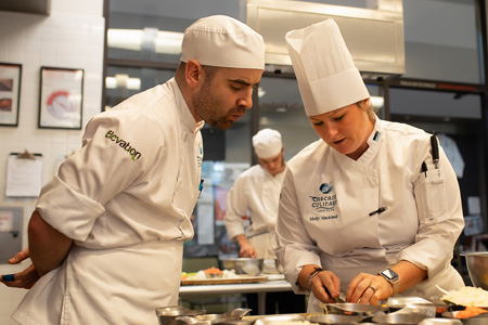 Culinary Instructor demonstrating knife cuts to a student