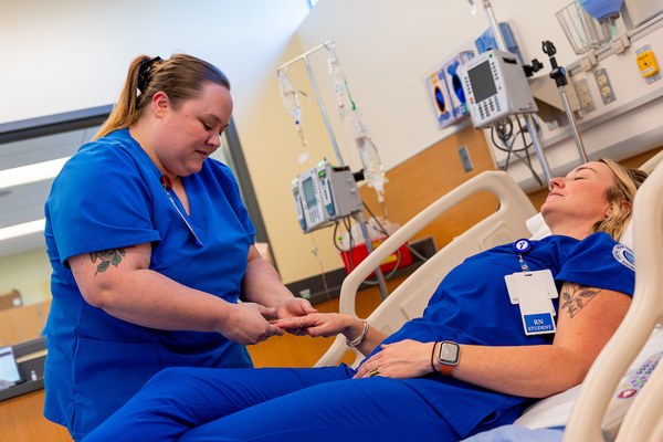 Student performing a health evaluation assessment to demonstrate their knowledge